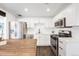 Bright kitchen with stainless steel appliances, white cabinets, herringbone backsplash, and gas range at 1742 S Alcott St, Denver, CO 80219