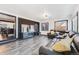 Open concept living room boasts brick accent wall, sleek hardwood floors, and comfortable sectional seating at 1742 S Alcott St, Denver, CO 80219