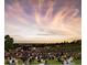 Image of an outdoor concert at Ruby Hill Park with a large crowd and a colorful sunset sky at 1742 S Alcott St, Denver, CO 80219