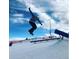 Image of a snowboarder in mid-air at the Ruby Hill Rail Yard ski terrain park with clear skies and snow obstacles at 1742 S Alcott St, Denver, CO 80219
