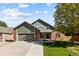 Two-story brick home with a green accent, attached garage, and landscaped lawn at 1563 E 131St Pl, Thornton, CO 80241