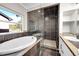 Elegant bathroom with soaking tub, walk-in shower, and dark tile at 9128 Hillview Rd, Morrison, CO 80465