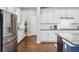 Modern kitchen with stainless steel appliances and white cabinets at 3386 Ulster St, Denver, CO 80238