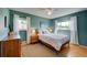 Bright bedroom with wood floors, mid-century furniture, and large windows at 3701 W Greenwood Pl, Denver, CO 80236