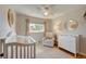 Neutral Bedroom with crib, dresser, and cozy armchair at 3701 W Greenwood Pl, Denver, CO 80236