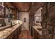 Basement bar area with brick flooring, stone archway, shelving, and stainless steel appliances at 6302 Charrington Dr, Cherry Hills Village, CO 80111