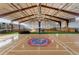 Indoor basketball court boasts bright lighting and a custom Jayhawks logo at 6302 Charrington Dr, Cherry Hills Village, CO 80111