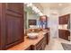 Bathroom with double sink vanity with stone countertop and dark wood cabinetry at 6302 Charrington Dr, Cherry Hills Village, CO 80111