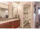 Bathroom with double vanity, white marble countertop, decorative backsplash, and step-in shower with glass door at 6302 Charrington Dr, Cherry Hills Village, CO 80111