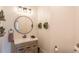Powder room with modern vanity, round mirror, decorative wreaths and light fixture at 6302 Charrington Dr, Cherry Hills Village, CO 80111