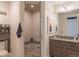 Modern bathroom showcasing glass shower, marble counter, and brown wooden cabinets at 6302 Charrington Dr, Cherry Hills Village, CO 80111