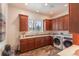 Functional laundry room with wood cabinets, sink, and modern washer and dryer at 6302 Charrington Dr, Cherry Hills Village, CO 80111
