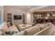 Comfortable basement living room with a large sectional sofa, stone archway to bar area, and TV at 6302 Charrington Dr, Cherry Hills Village, CO 80111