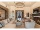 Inviting living room featuring stone accents, a cozy fireplace, and an elegant chandelier at 6302 Charrington Dr, Cherry Hills Village, CO 80111