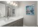 Well-lit bathroom features a single sink vanity with modern fixtures and a large mirror at 8010 Blue River Ave, Littleton, CO 80125