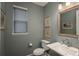 Lovely half bathroom with a pedestal sink, a toilet, and grey walls at 8010 Blue River Ave, Littleton, CO 80125