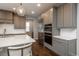 A close up of the kitchen shows grey cabinets and stainless appliances, complete with a large island at 8010 Blue River Ave, Littleton, CO 80125