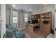 Charming home office space with plush blue chairs, a wooden desk, and a large bookshelf at 8010 Blue River Ave, Littleton, CO 80125