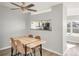 Dining room featuring modern table, ceiling fan, and a view of the kitchen at 12814 Jasmine St # C, Thornton, CO 80602
