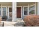 Inviting front door with sidelight windows and a cozy chair on a well-maintained front porch at 12814 Jasmine St # C, Thornton, CO 80602