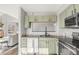 Open kitchen view with stylish light green cabinetry and view to the living room at 12814 Jasmine St # C, Thornton, CO 80602