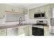 Corner view of kitchen showcasing stainless appliances and modern, stylish light green cabinets at 12814 Jasmine St # C, Thornton, CO 80602