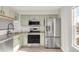 Kitchen with stainless steel appliances and stylish light green cabinetry at 12814 Jasmine St # C, Thornton, CO 80602