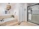 Bright bathroom featuring a soaking tub and separate glass enclosed shower at 13340 Saint Paul St, Thornton, CO 80241