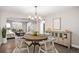 Open-concept dining room with wood table, chandelier, and sideboard cabinet at 13340 Saint Paul St, Thornton, CO 80241