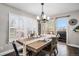 Elegant dining room featuring a large table, modern chandelier, and plenty of natural light at 13340 Saint Paul St, Thornton, CO 80241