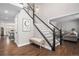 Inviting entryway with dark wood floors, staircase, and bench, leading to an open-concept living space at 13340 Saint Paul St, Thornton, CO 80241