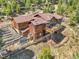 Elevated view of the home showcasing a tiered deck, chicken coop, and lush surroundings at 33121 Lynx Ln, Evergreen, CO 80439