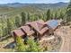 Aerial view of a beautiful home surrounded by lush greenery and mountain scenery at 33121 Lynx Ln, Evergreen, CO 80439