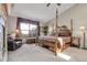 The main bedroom includes a four-poster bed, view windows, an armchair, and a chest at 33121 Lynx Ln, Evergreen, CO 80439