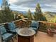 Outdoor deck with comfortable seating, a fire pit, and breathtaking mountain views at 33121 Lynx Ln, Evergreen, CO 80439