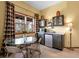 This dining area contains a glass table, a mini fridge, and dark wooden cabinets at 33121 Lynx Ln, Evergreen, CO 80439