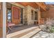 Charming front porch featuring stone accents, a wooden deck, and a cozy seating area with a view at 33121 Lynx Ln, Evergreen, CO 80439