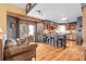 Modern kitchen and living room featuring hardwood floors, island seating, and stainless steel appliances at 33121 Lynx Ln, Evergreen, CO 80439
