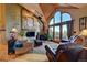 Cozy living room featuring a stone fireplace, wood stove, comfortable seating, and scenic views through large windows at 33121 Lynx Ln, Evergreen, CO 80439