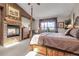 Spacious main bedroom with a cozy fireplace, four-poster bed, and serene views at 33121 Lynx Ln, Evergreen, CO 80439