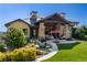 Stunning backyard features stone pillars, covered patio, outdoor seating, and lush landscaping at 7767 Dante Dr, Littleton, CO 80125