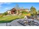 Landscaped backyard boasts a stone patio, lounge chairs, and manicured lawns, ideal for relaxation at 7767 Dante Dr, Littleton, CO 80125