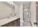 Well-lit bathroom featuring a sleek vanity, stylish mirror, and a glass-enclosed shower at 7767 Dante Dr, Littleton, CO 80125