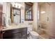 Modern bathroom with glass enclosed shower, dark wood vanity and stylish fixtures at 7767 Dante Dr, Littleton, CO 80125