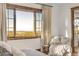 Sun-filled bedroom with large windows offering scenic views and cozy seating area at 7767 Dante Dr, Littleton, CO 80125