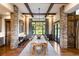 Elegant dining room with a large wooden table, exposed beams, stone accents, and backyard views at 7767 Dante Dr, Littleton, CO 80125
