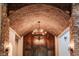 Elegant foyer with a brick barrel ceiling, stone pillars, sconces, and a chandelier providing a grand entrance at 7767 Dante Dr, Littleton, CO 80125