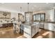 Open kitchen with large island, breakfast bar seating, stainless steel appliances, and hardwood floors at 7767 Dante Dr, Littleton, CO 80125