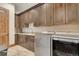 Well-lit laundry room featuring granite counters, wooden cabinets, and modern washer and dryer at 7767 Dante Dr, Littleton, CO 80125