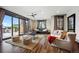 Bright living room with hardwood floors, stone accent wall, and large windows to the outdoor view at 7767 Dante Dr, Littleton, CO 80125